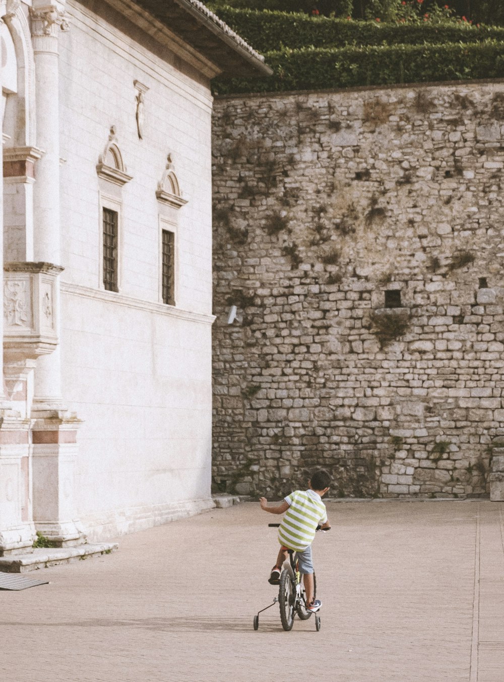 a little boy riding a bike in front of a building