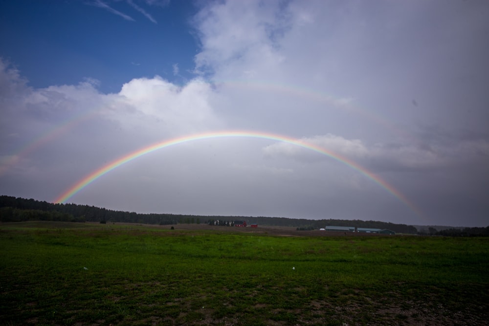 a double rainbow in the sky over a field