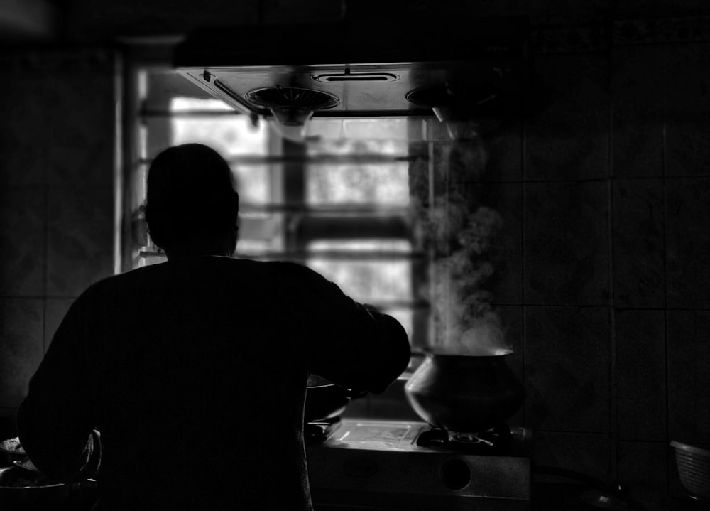 a man standing in a kitchen next to a sink