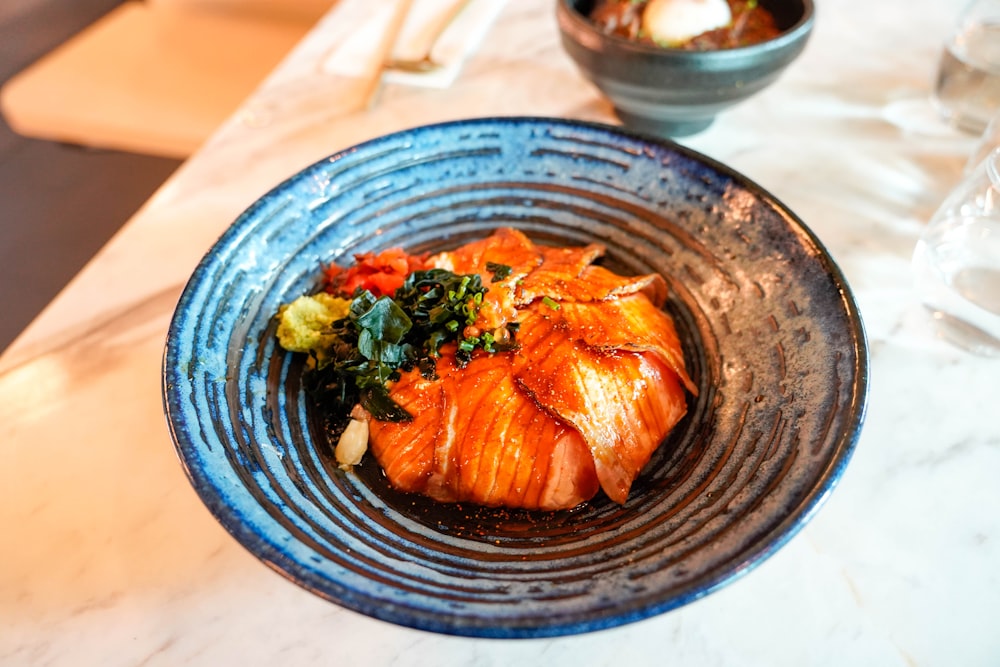 a blue bowl filled with food on top of a table