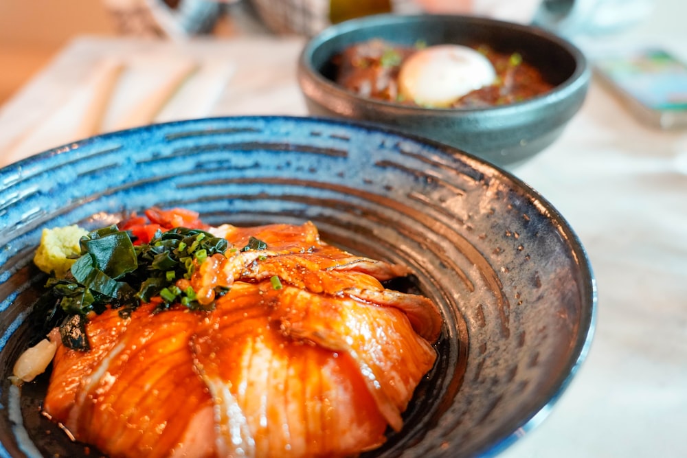 a blue bowl filled with food on top of a table