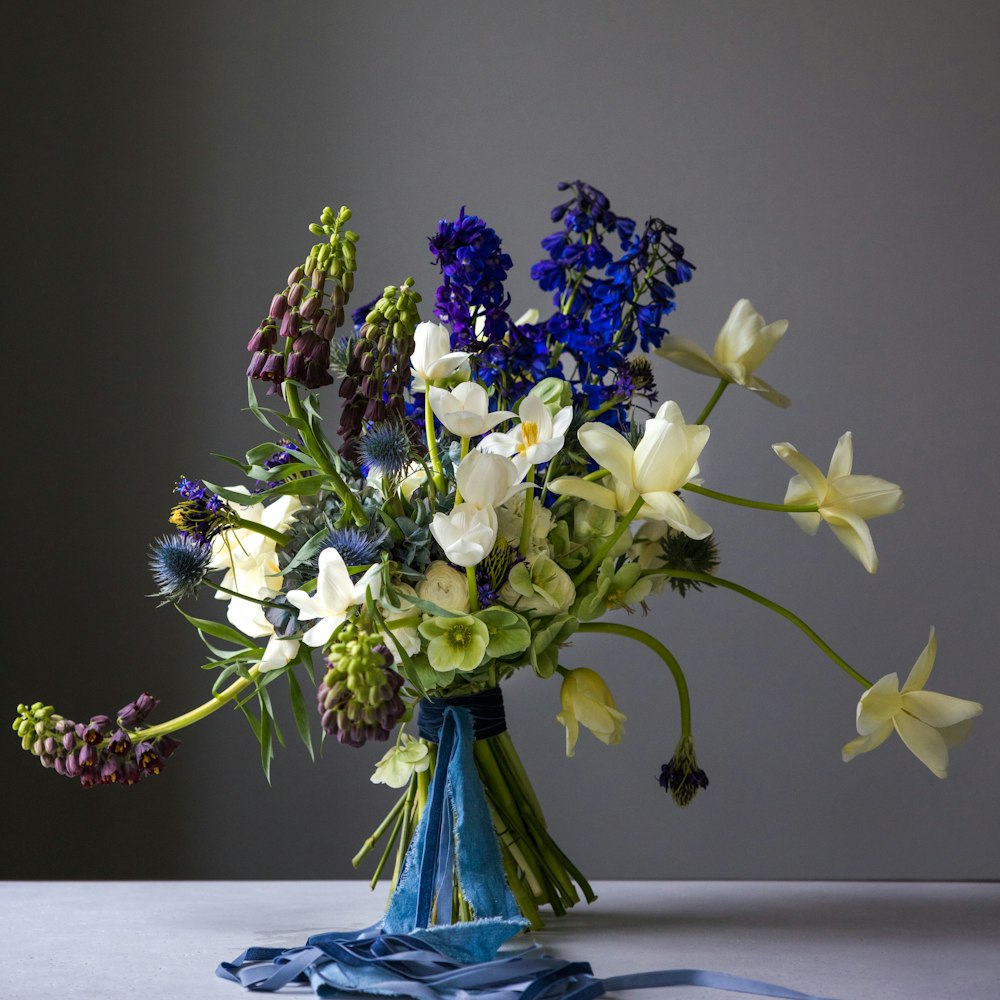 a vase filled with lots of flowers on top of a table