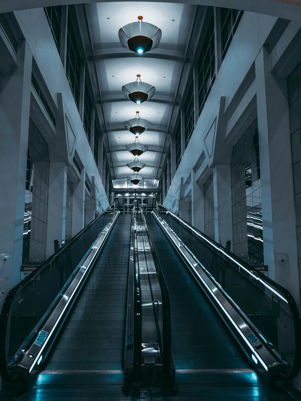 an empty escalator in a building with lights on