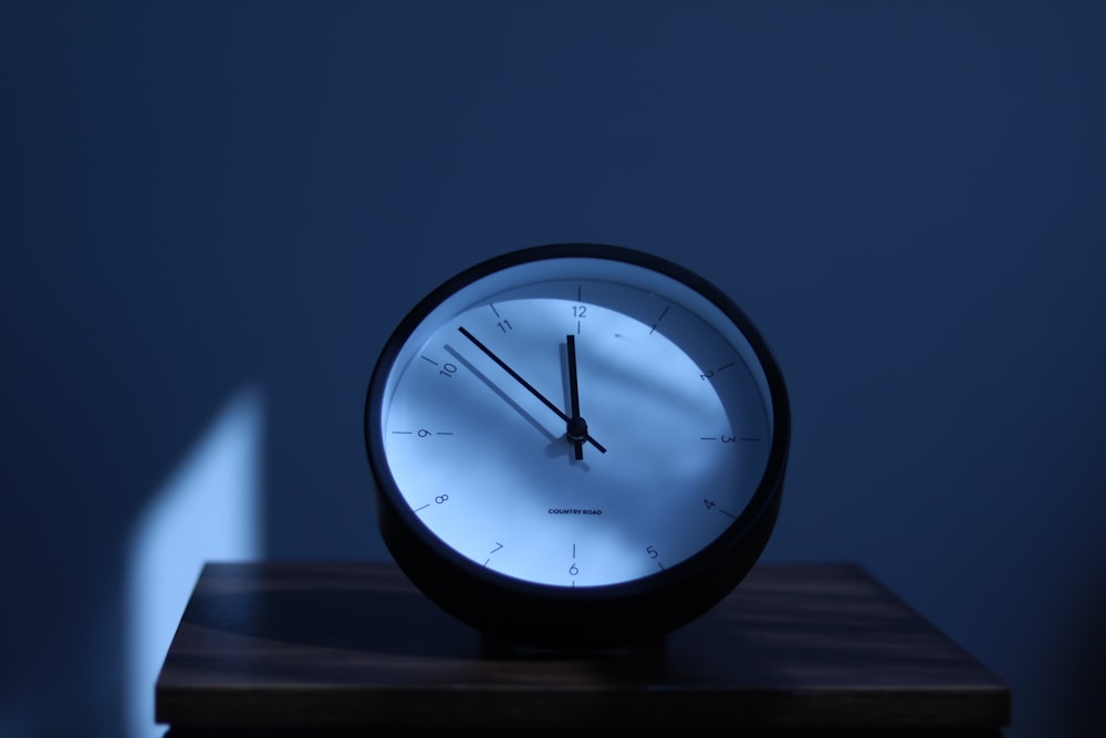 a clock sitting on top of a wooden table