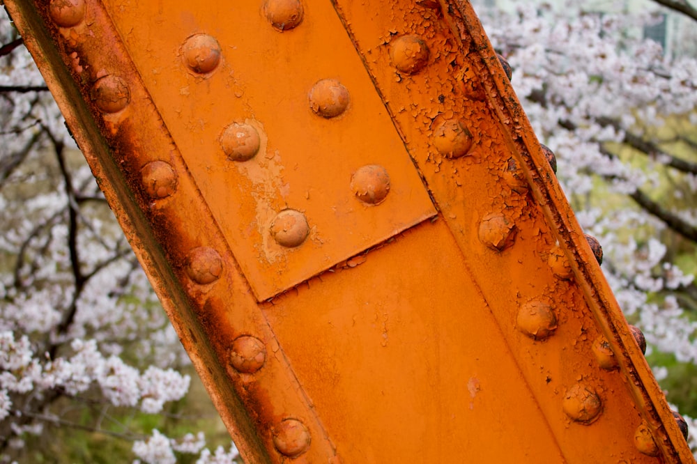 a close up of a rusted metal structure near a tree