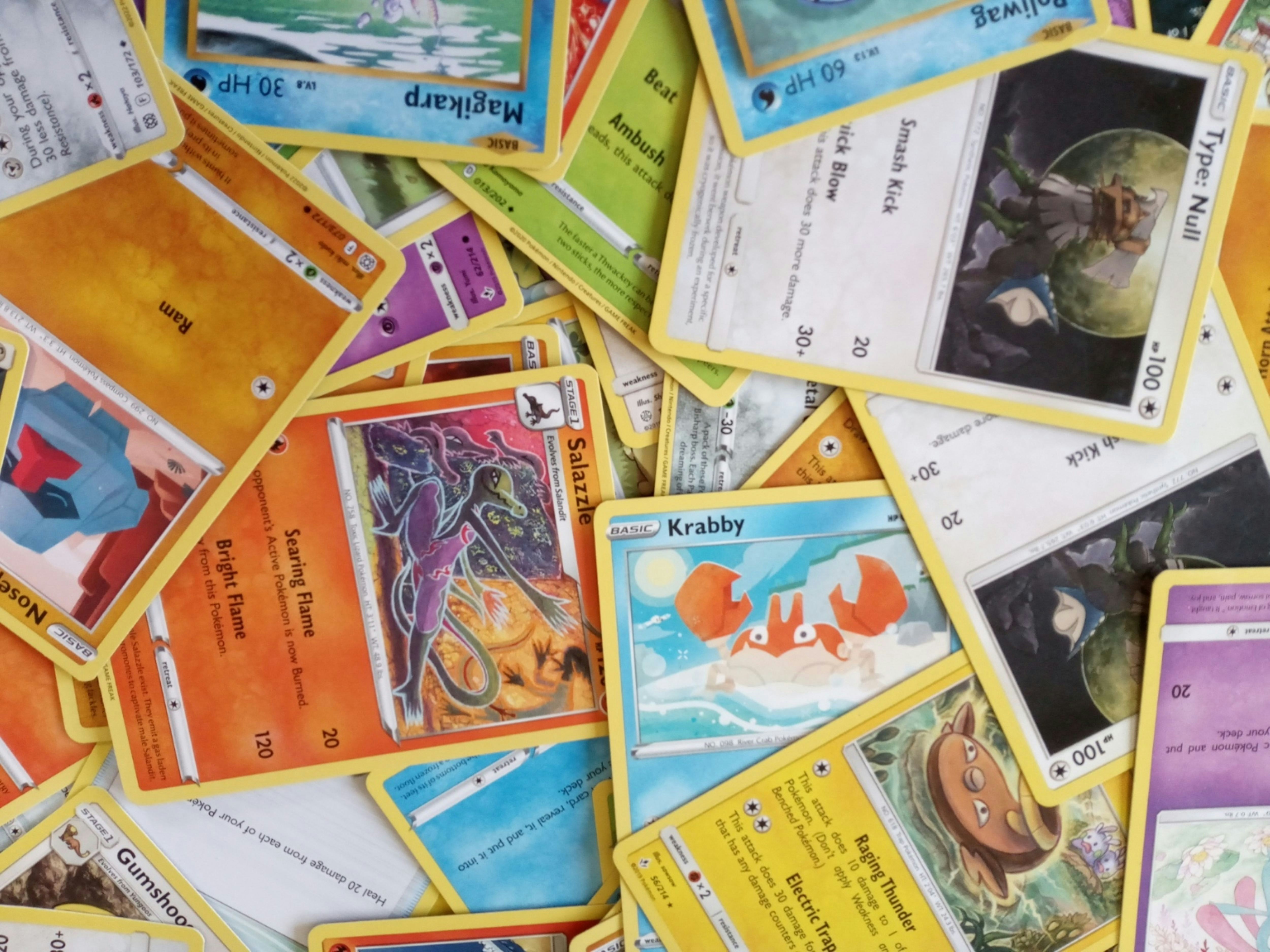 Pokémon trading cards spread on a table with colorful holographic foil effects