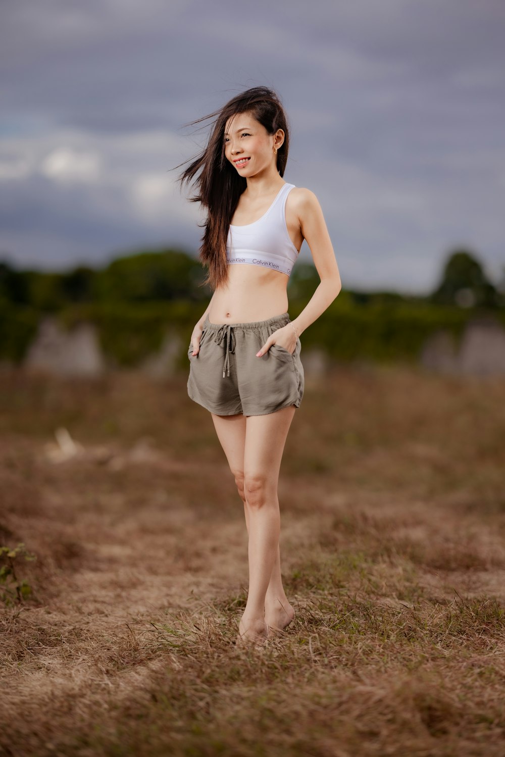 a woman standing in a field with her hands on her hips