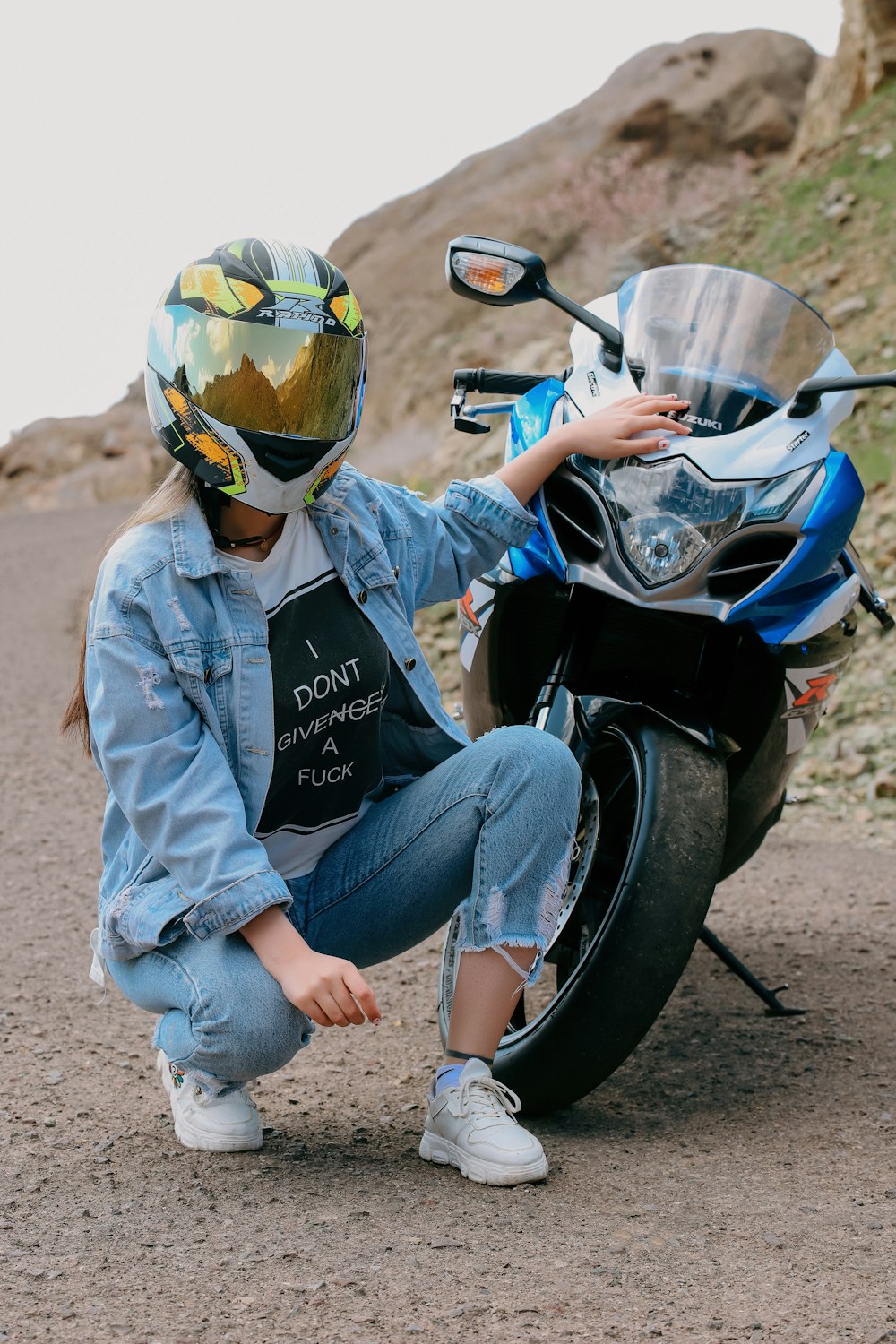 a person sitting on the ground next to a motorcycle