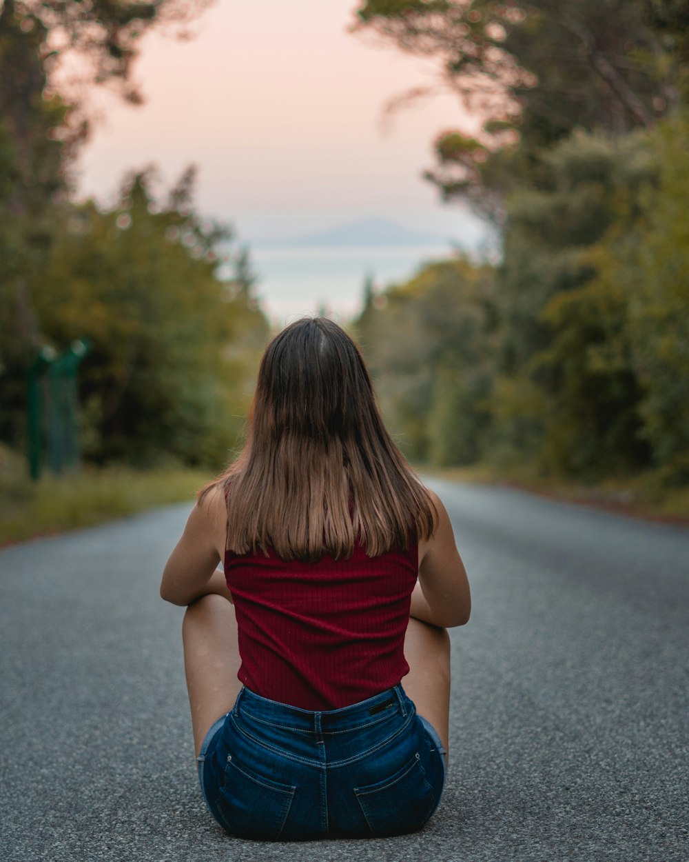 a woman sitting on the side of a road