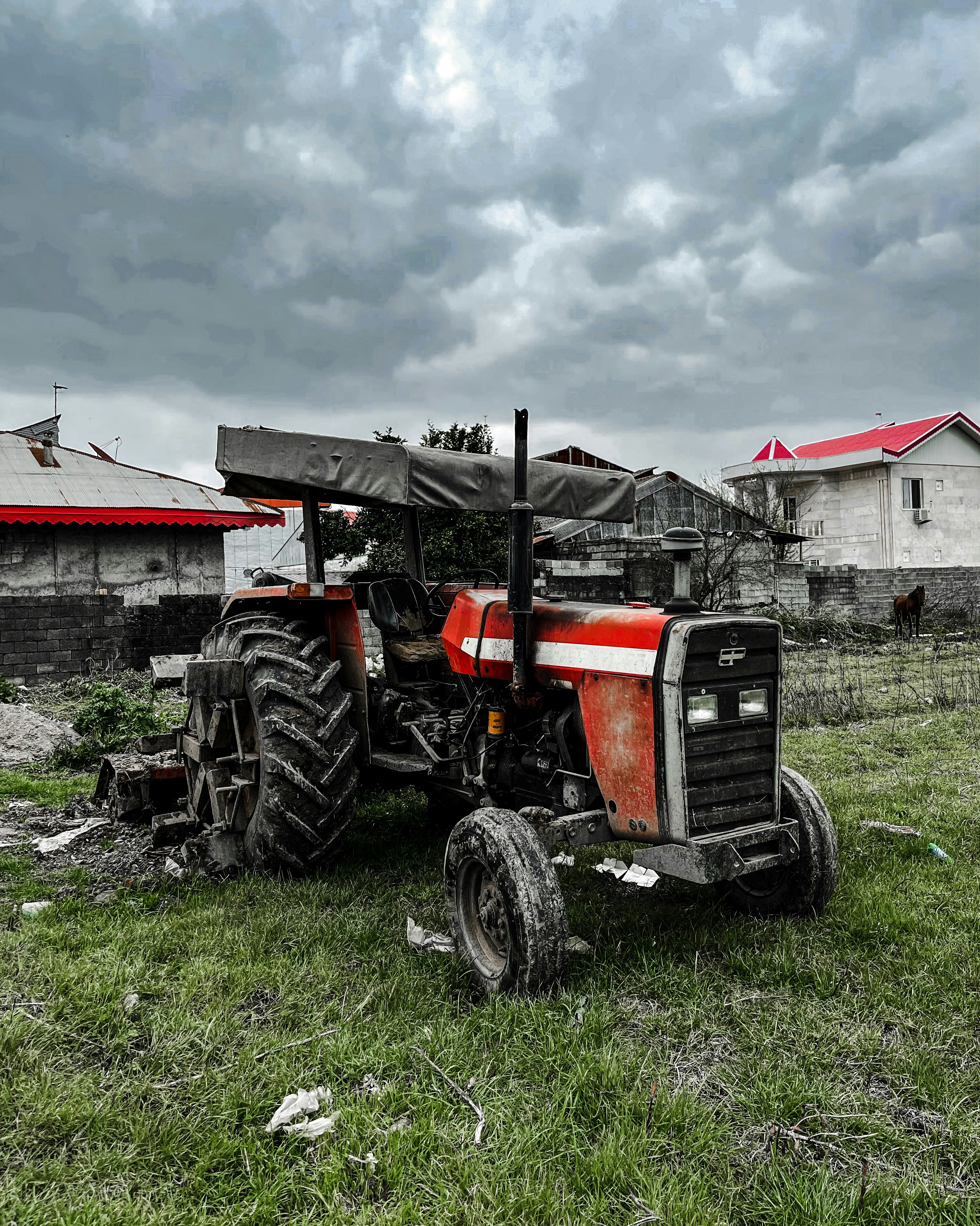 a red and black tractor sitting in a field