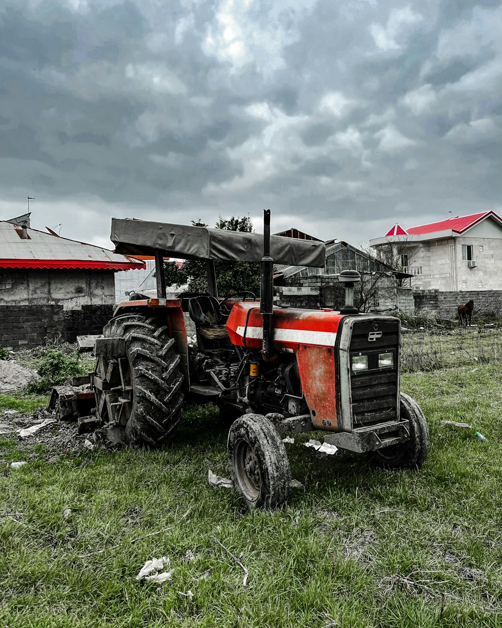 a red and black tractor sitting in a field