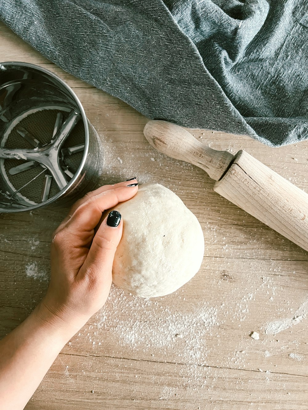 a person is kneading dough on a wooden table