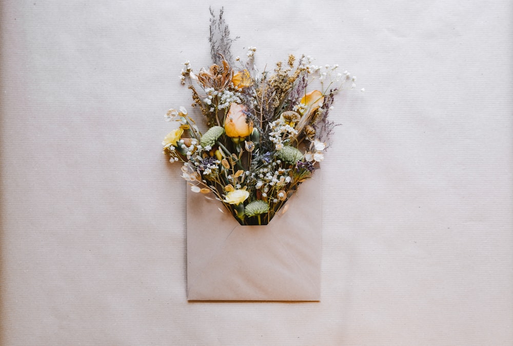 a bouquet of flowers is placed in an envelope