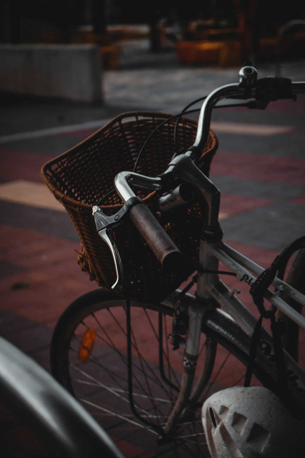 a bicycle with a basket parked on a sidewalk