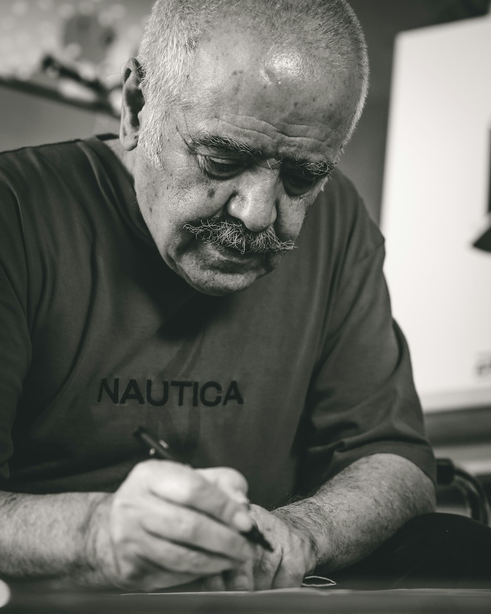 a man sitting at a table writing on a piece of paper