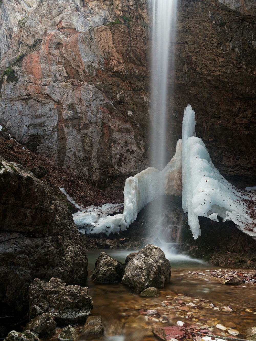 uma cachoeira com gelo nas rochas e água em cascata