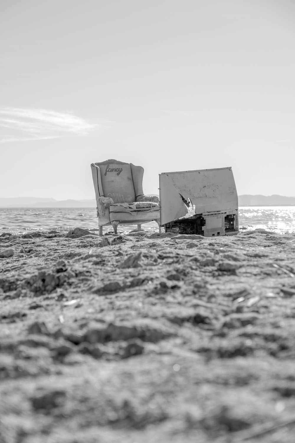 a couple of chairs sitting on top of a sandy beach