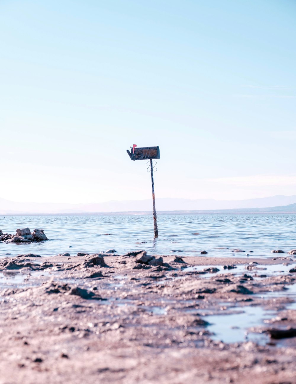 a sign on a pole in the middle of a body of water