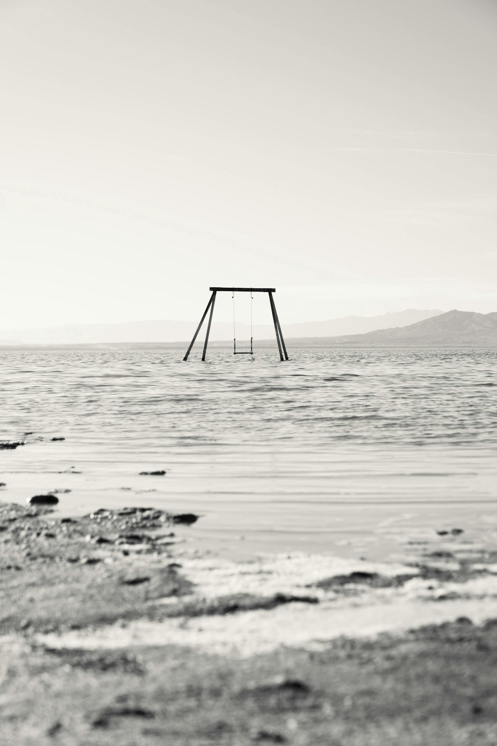 a swing sitting in the middle of a body of water