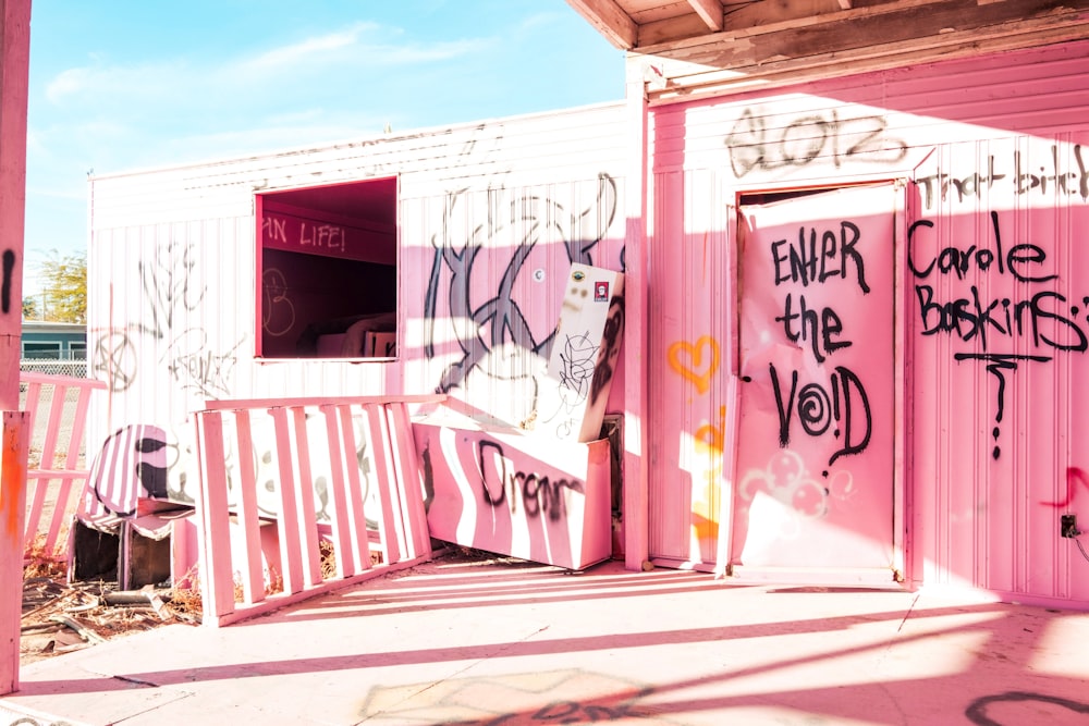 ein rosa Gebäude mit vielen Graffiti darauf