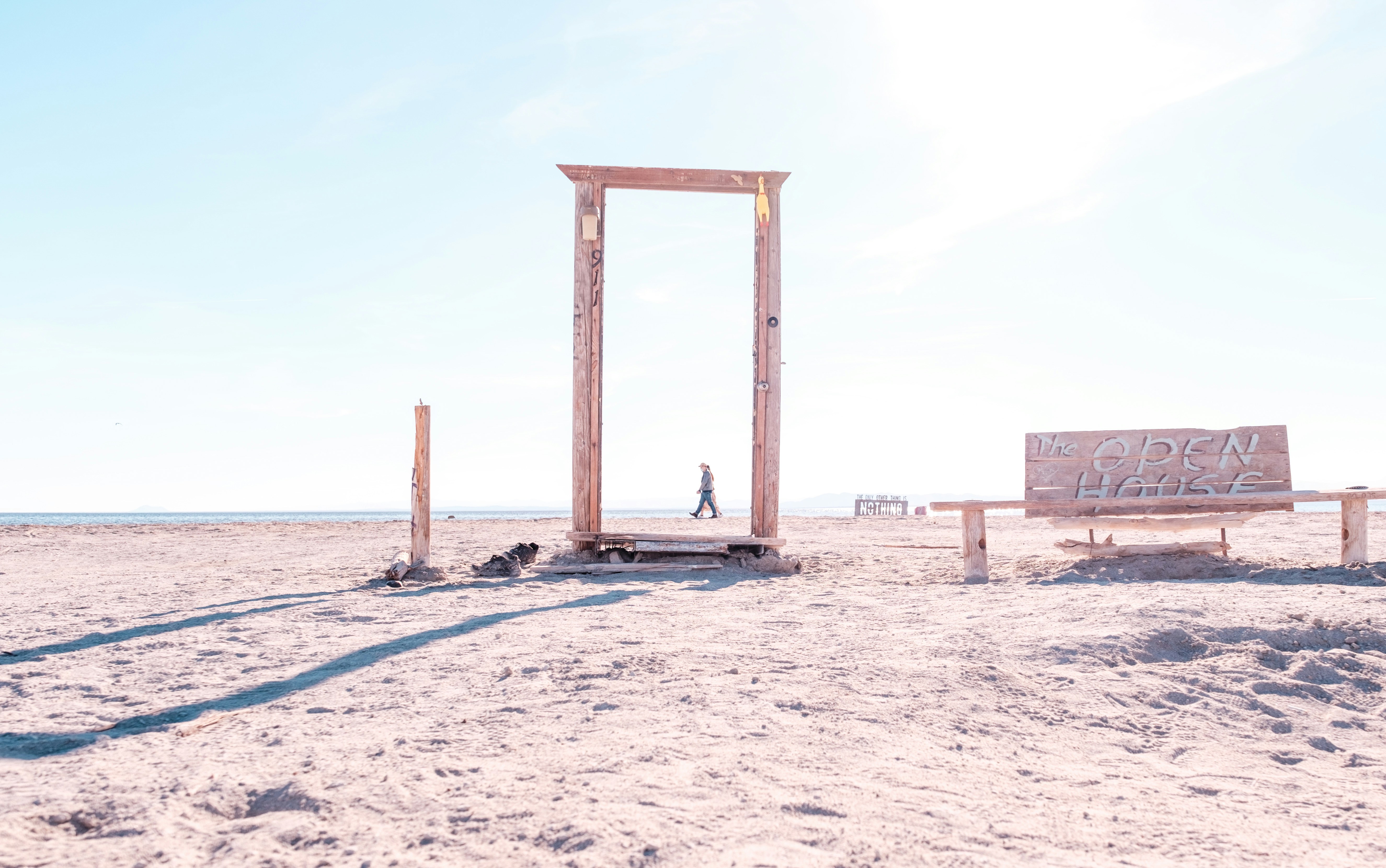 a wooden bench sitting on top of a sandy beach