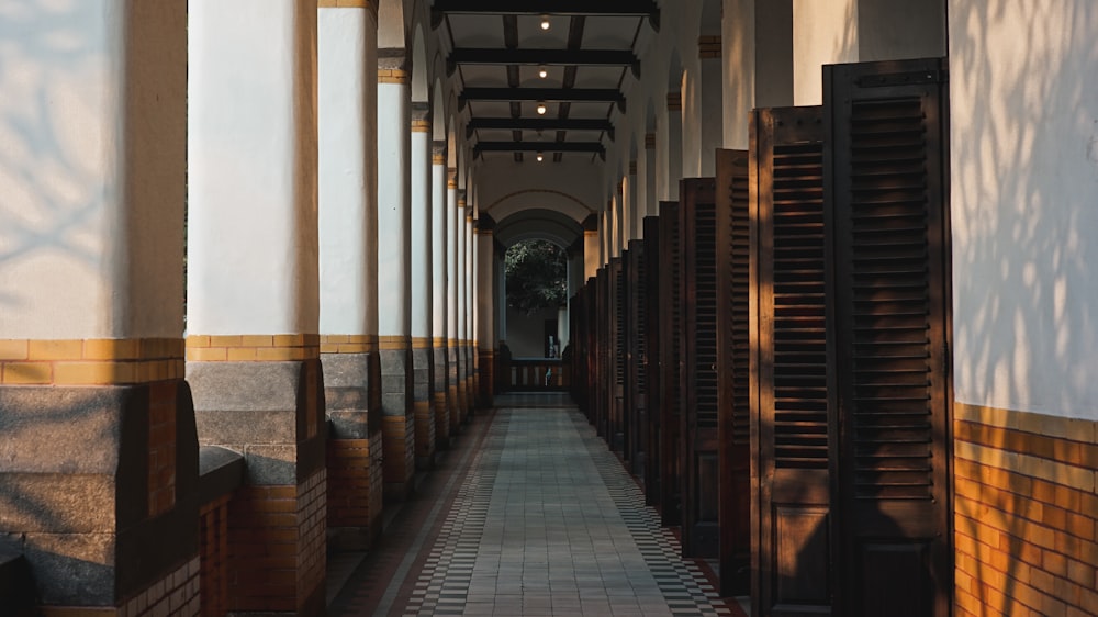 um longo corredor forrado com portas e janelas de madeira
