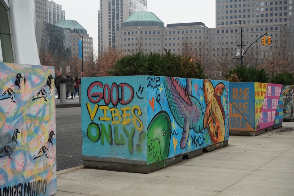 a row of colorful graffiti on the side of a road