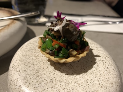 Close-up of a colorful summer vegetable tart with herbs and flaky crust.
