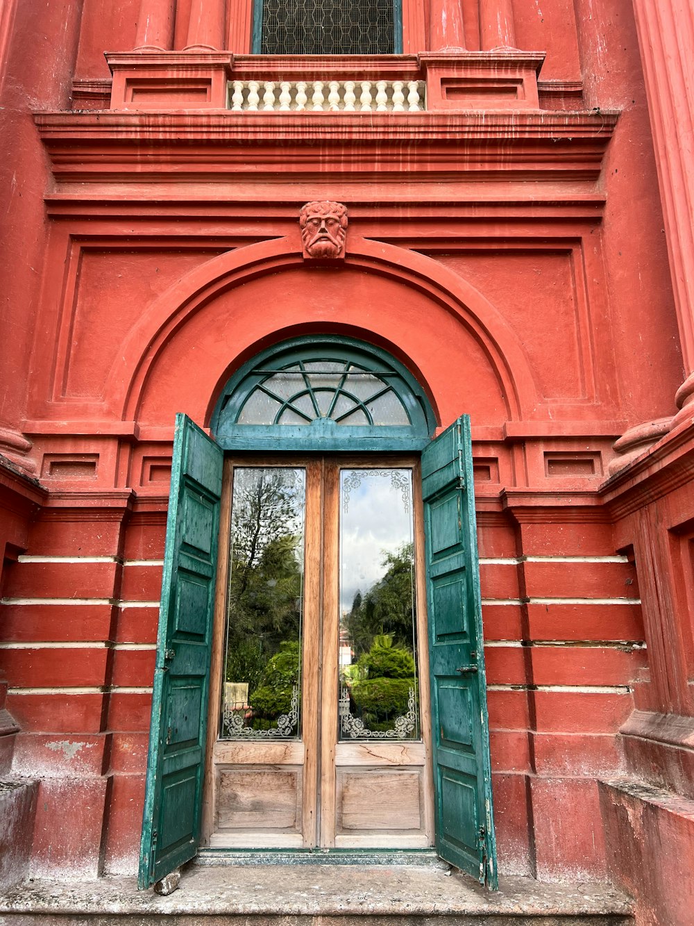 a red building with a green door and window