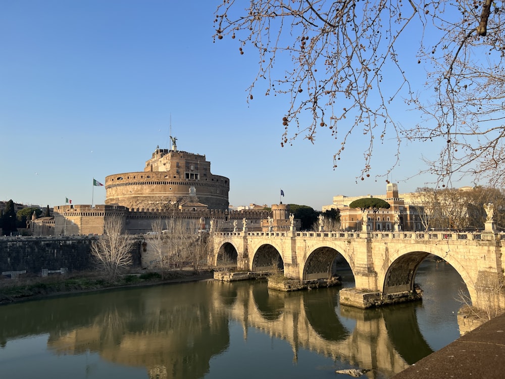 a bridge over a body of water with a castle in the background