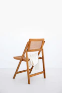 Close-up of a textured wool throw draped over a simple wooden chair.