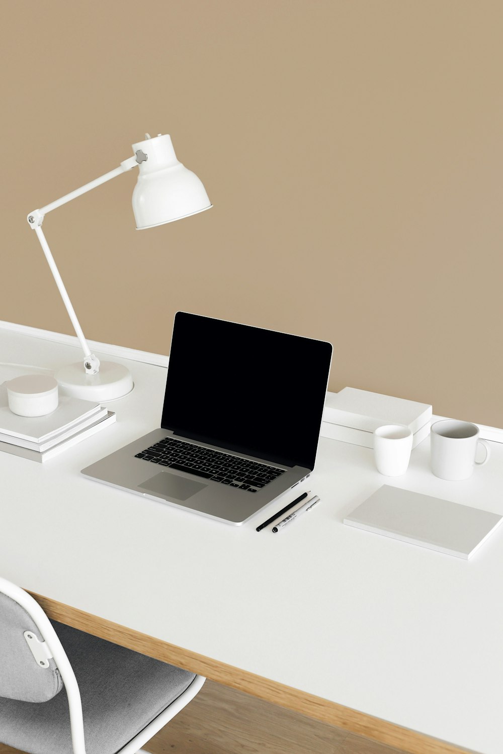 a laptop computer sitting on top of a white desk