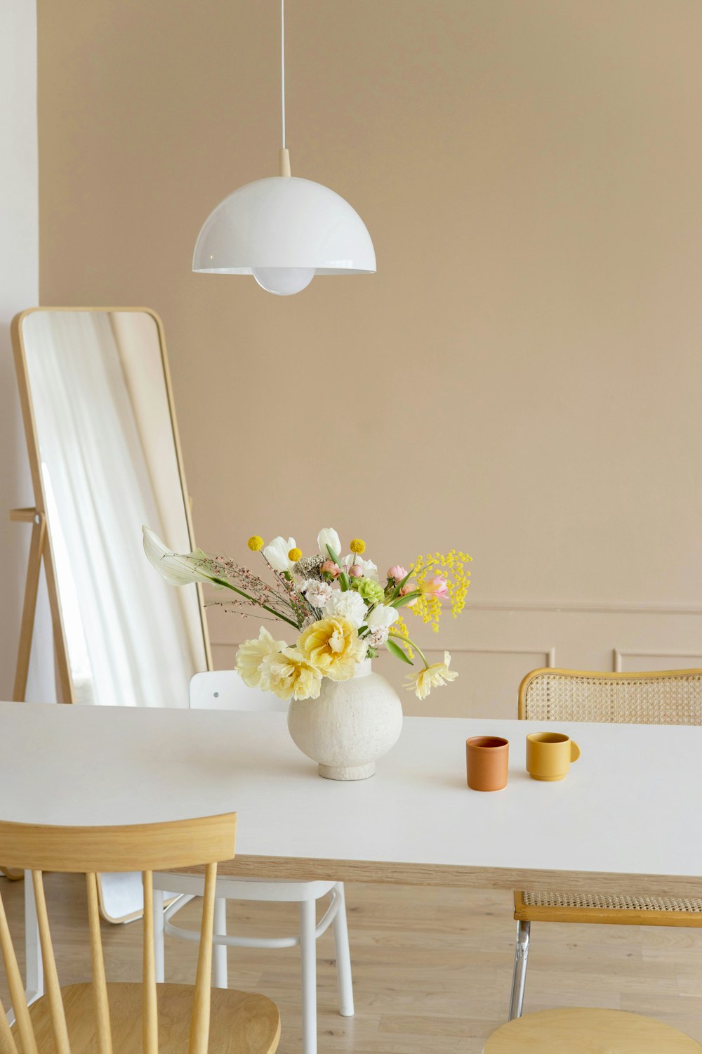 a white table with a vase of flowers on it