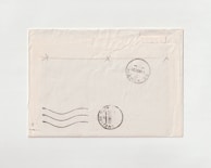 Close-up of a delicate vintage postcard corner with faded stamps and postmarks.