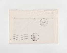 A vintage envelope with visible postmarks and a simple design. The envelope shows some signs of wear, with slight creases and discoloration in places. The postmarks indicate usage and add a historical element to the envelope.