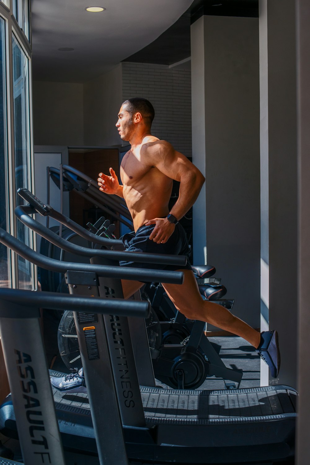 a man running on a treadmill in a gym