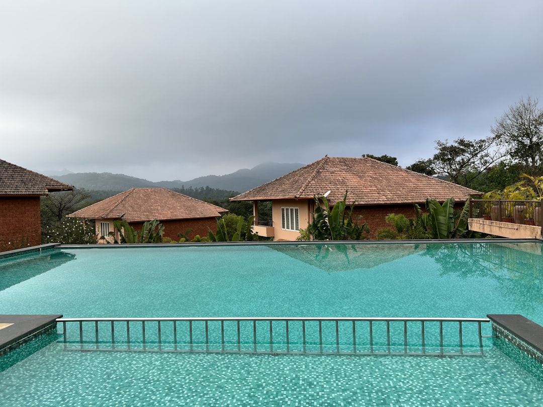 a large swimming pool next to a lush green hillside,