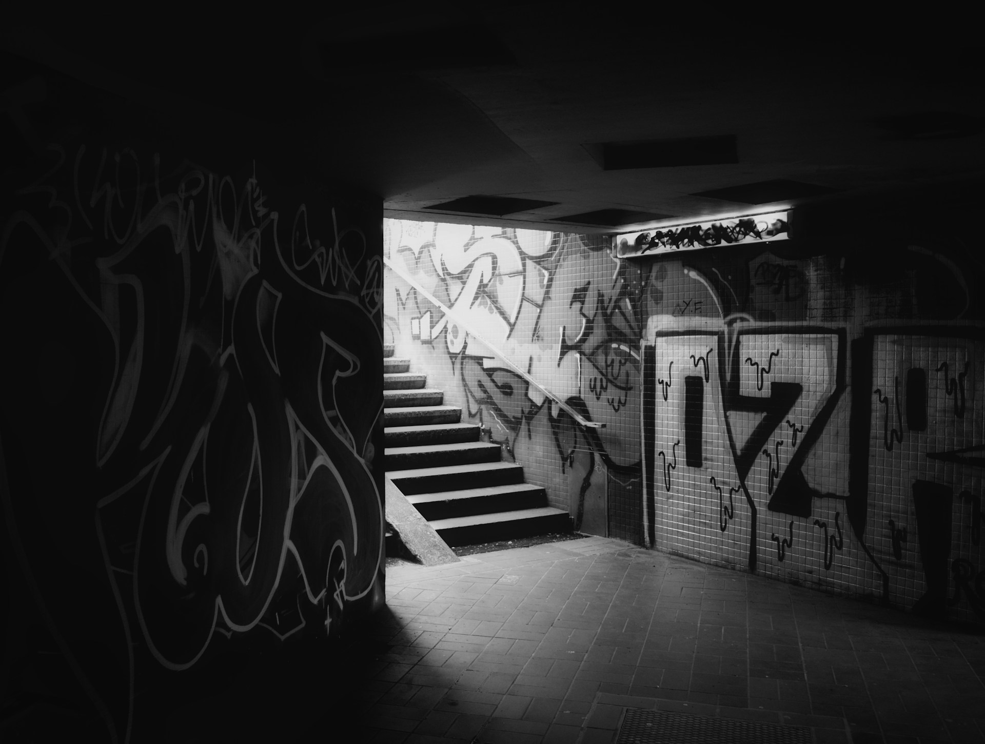 a black and white photo of graffiti on a wall