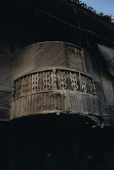 Photo showing the balcony before renovation with worn decking and visible water damage.