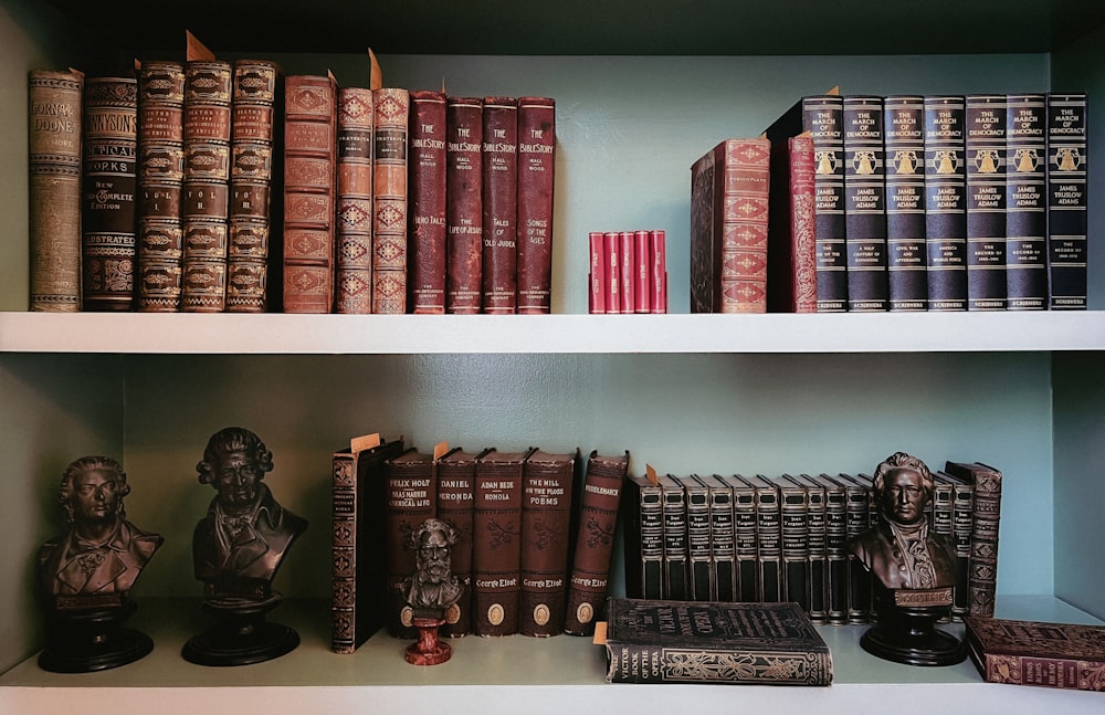 a row of books sitting on top of a white shelf