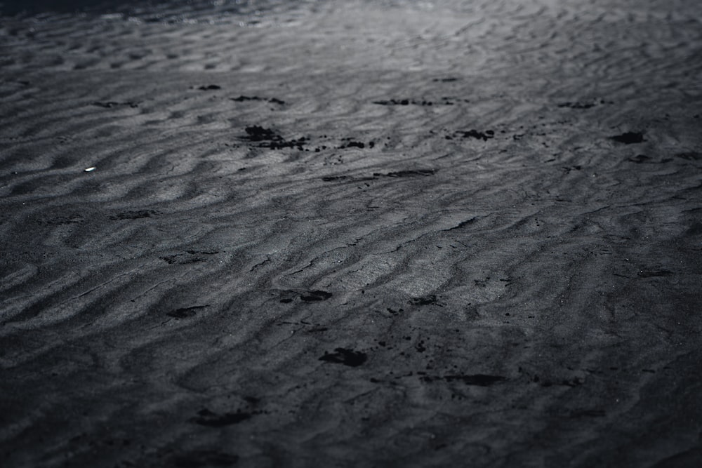 a black and white photo of footprints in the sand