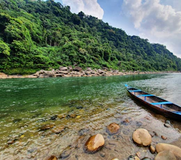 a boat is sitting on the shore of a river