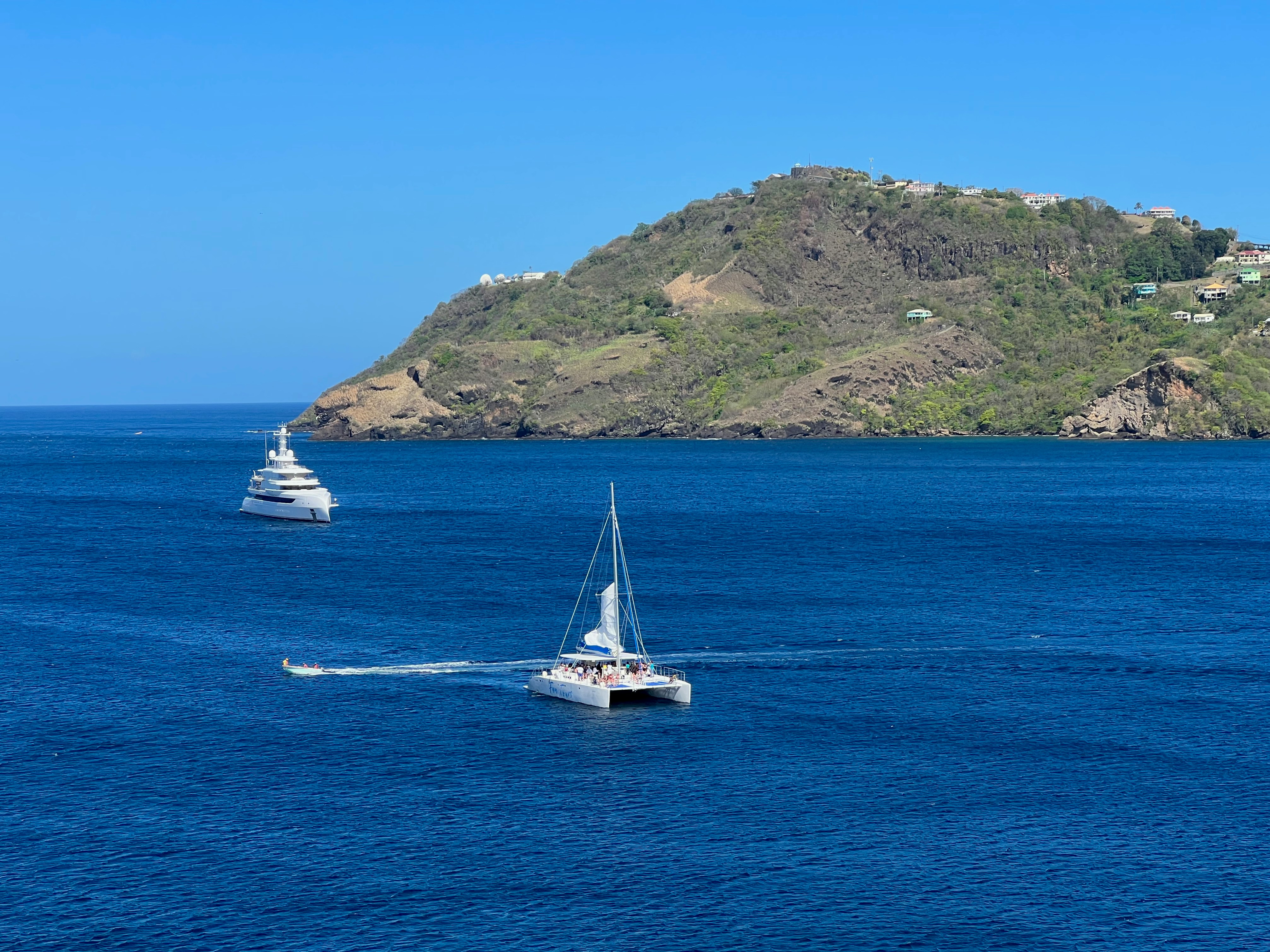 a couple of boats floating on top of a large body of water, 