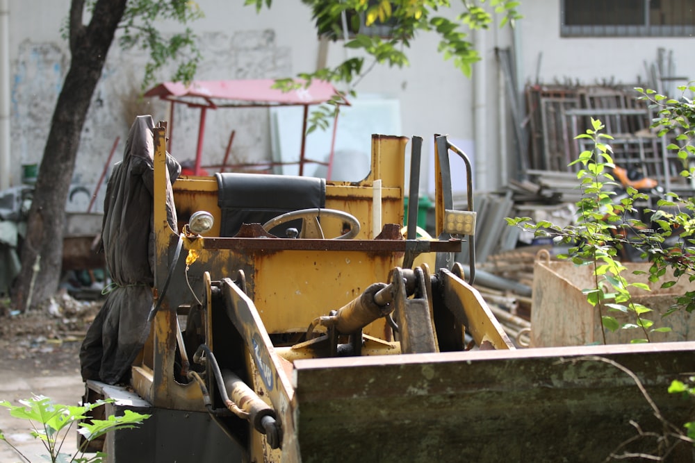 a yellow bulldozer sitting in the middle of a yard