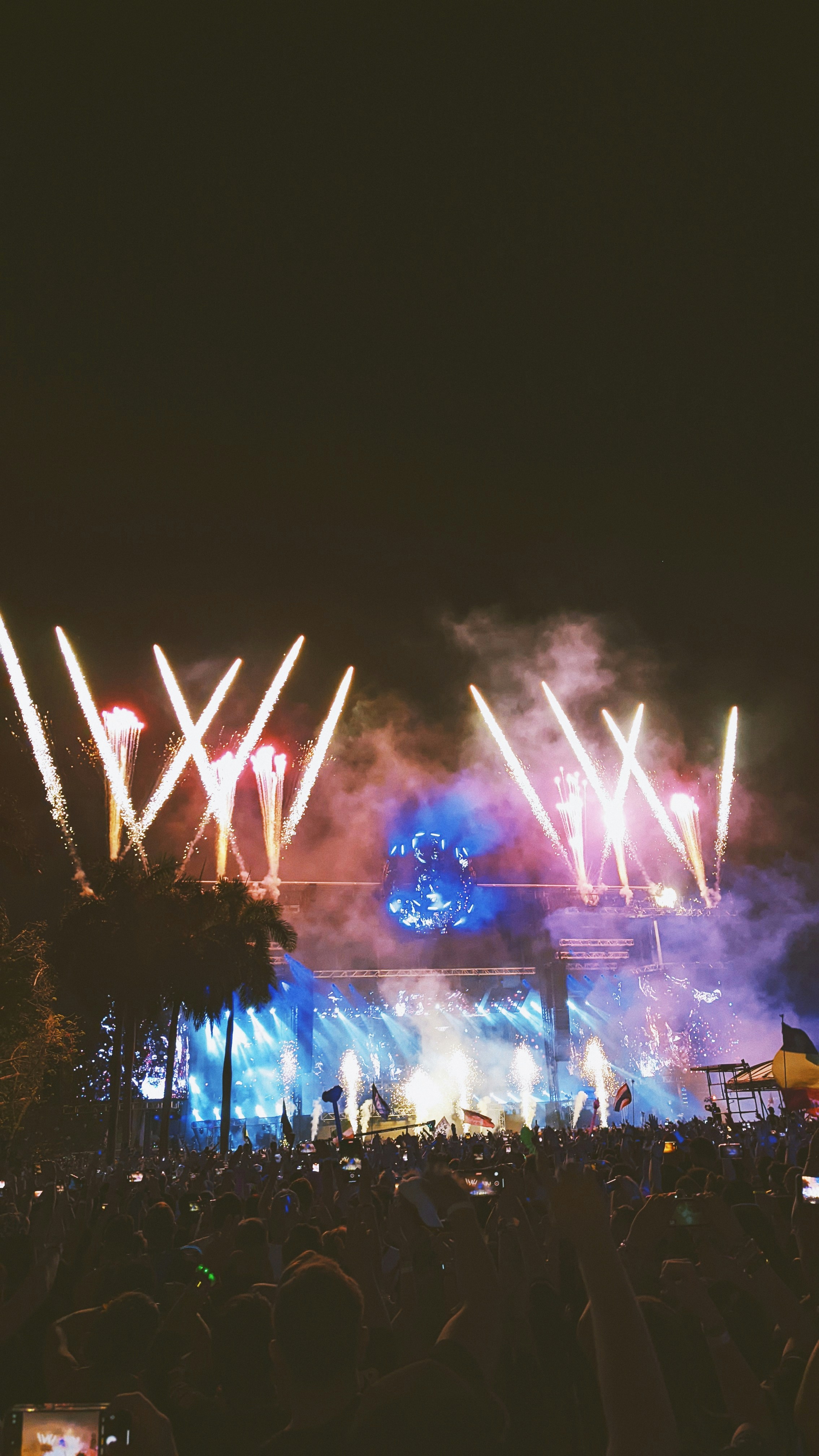 Rock concert stage with electric blue lighting and crowd, live performance scene