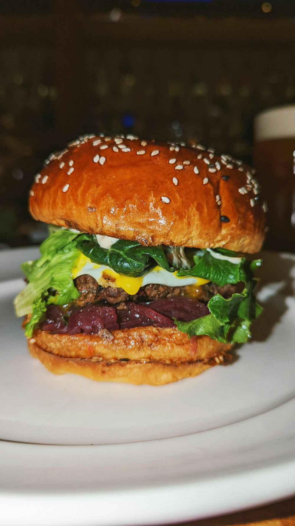 a hamburger with lettuce, cheese, and other toppings