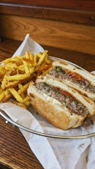 A cozy wooden table with a freshly made sandwich and a side of crispy fries.