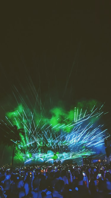 A vibrant 4K cinematic drone shot over a glowing festival crowd at night with neon purple and electric green lights.