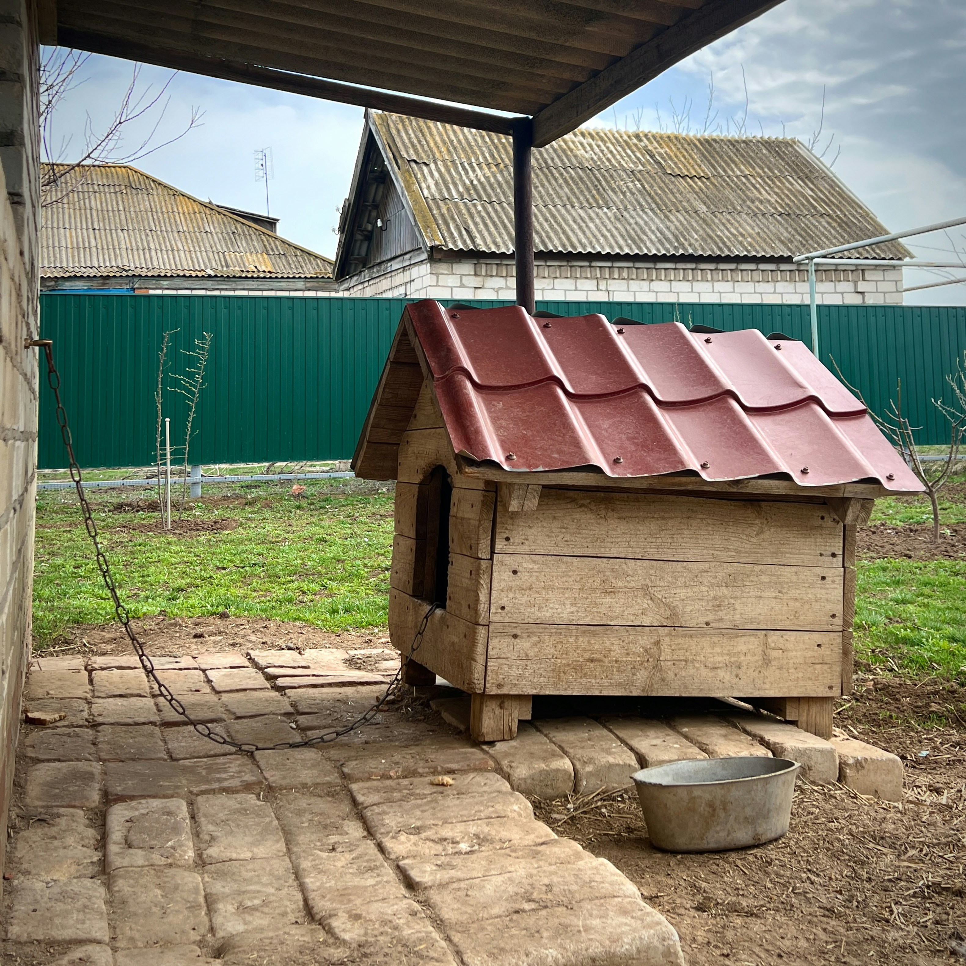 a small wooden dog house with a red roof