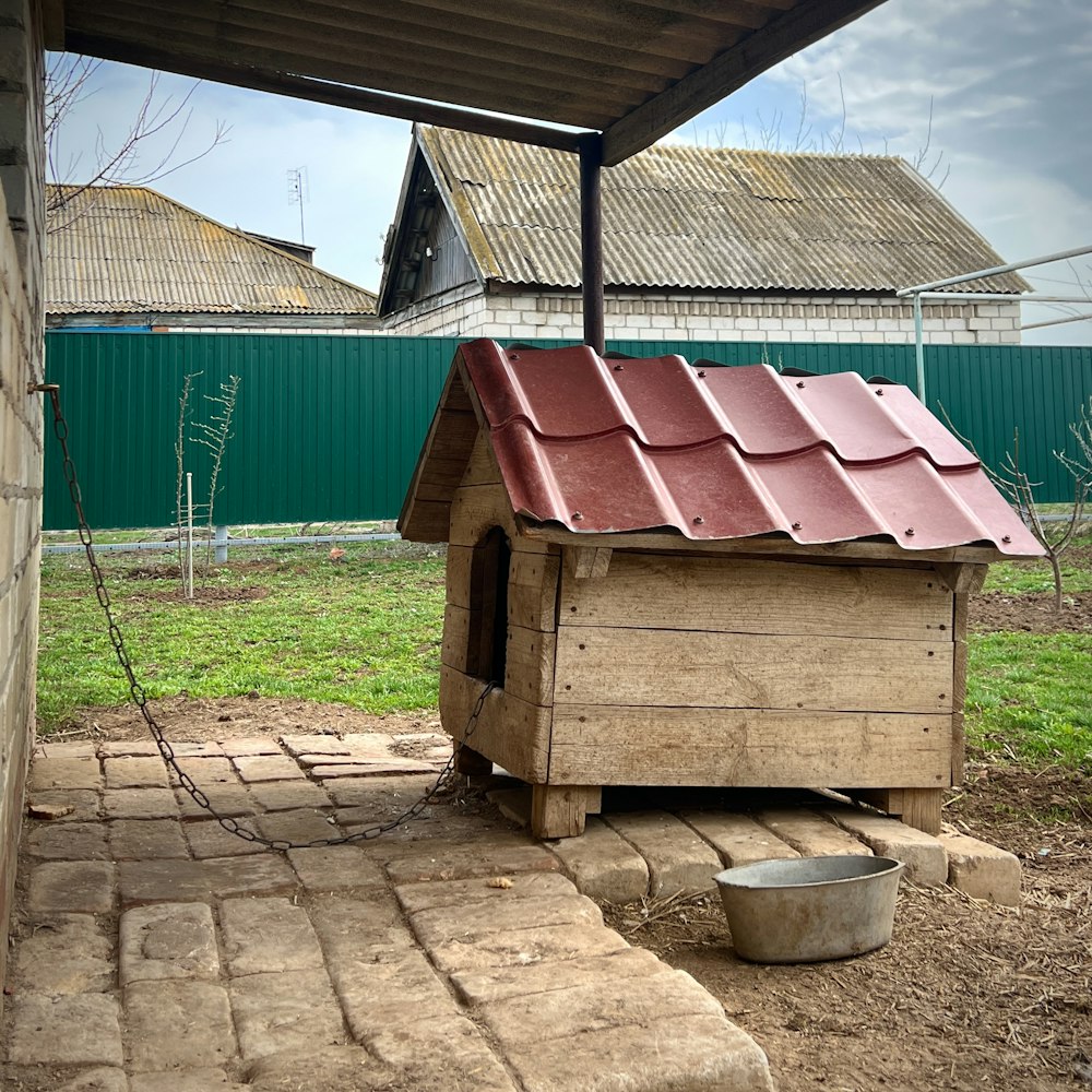 a small wooden dog house with a red roof